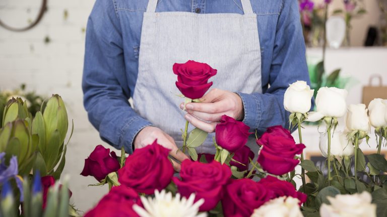 mid-section-male-florist-arranging-rose-flower-bouquet